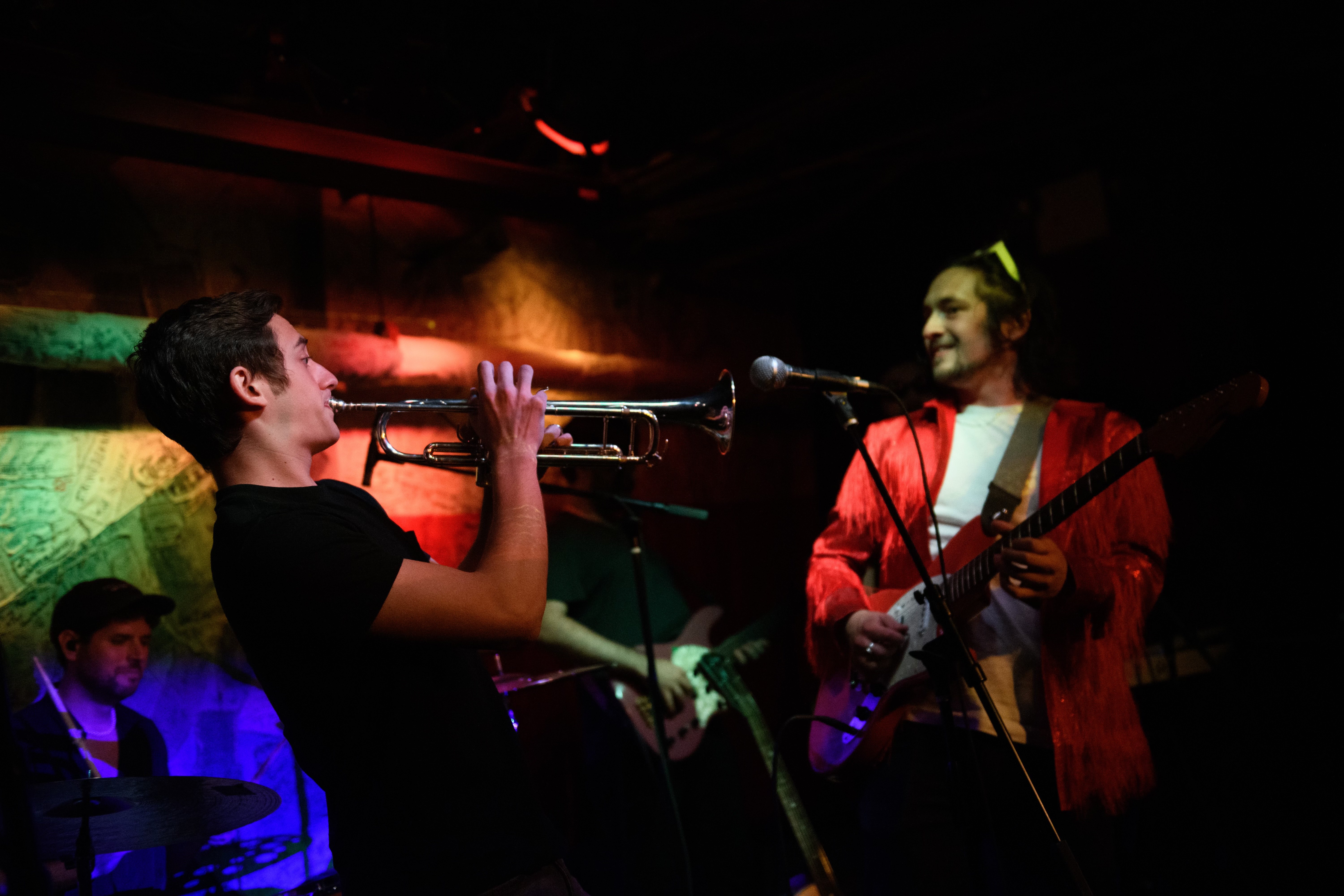 Dylan Satow playing trumpet on stage with warm lighting